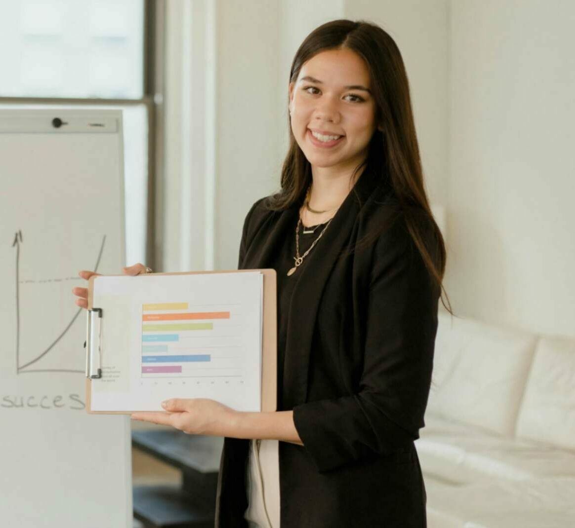 Woman holding documents and smiling for a customer testimonial.
