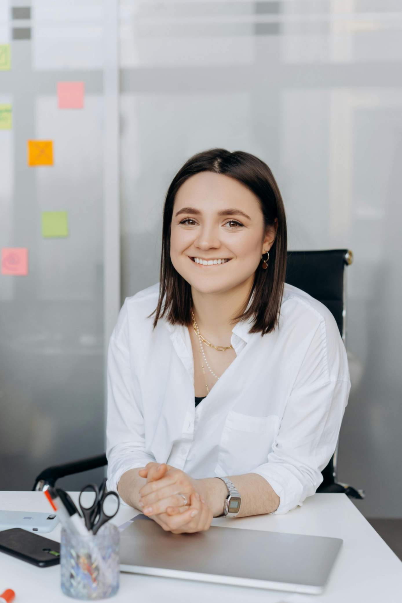 Woman sitting at a desk smiling for a customer testimonial