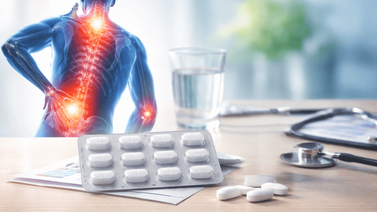 Blister pack of pain relief tablets on a desk with a glass of water and medical equipment, background showing highlighted spinal back pain.