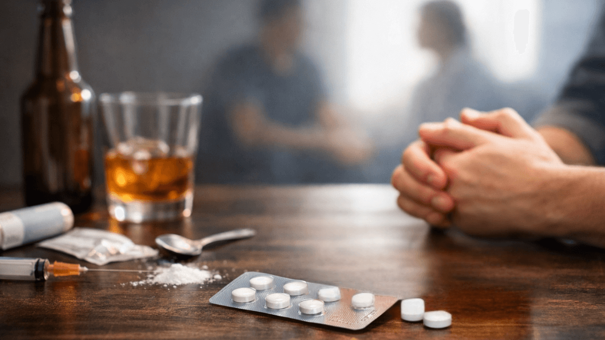 Alcohol and opioid misuse with tablets and syringes on a table, representing substance dependence treatment and recovery support.