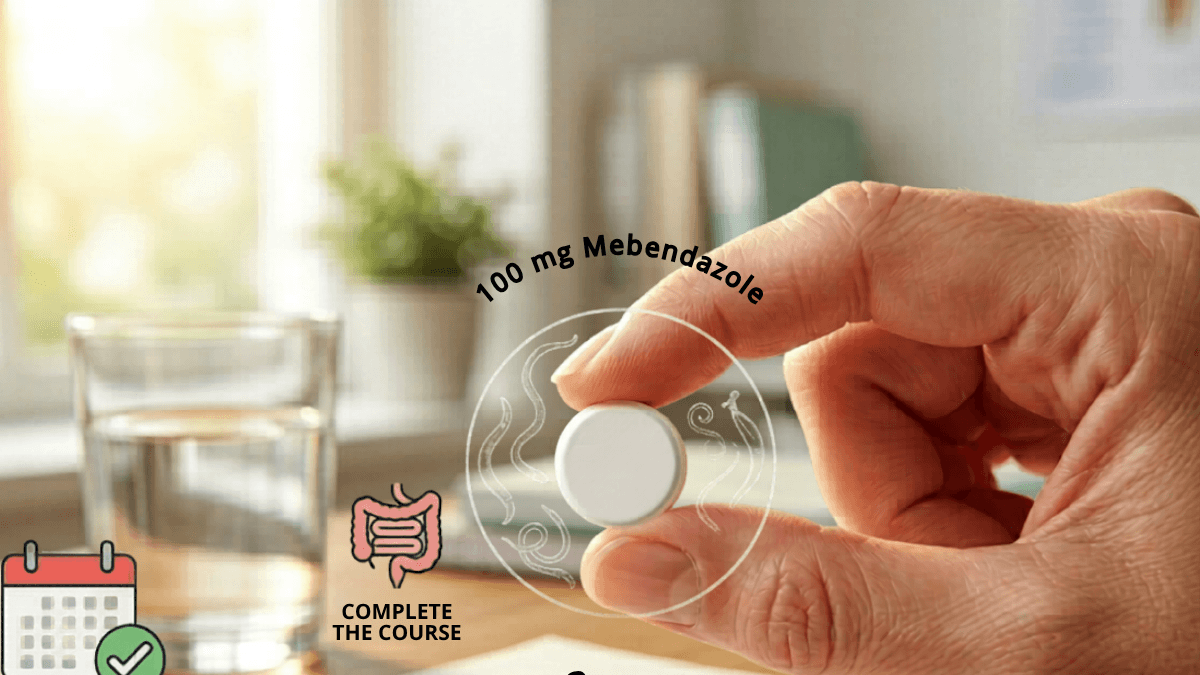 Mebentel 100 mg Mebendazole tablet held in hand — complete the full course